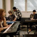 people in a class room playing pianos